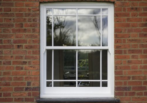 White uPVC sliding sash window with white astragal bars